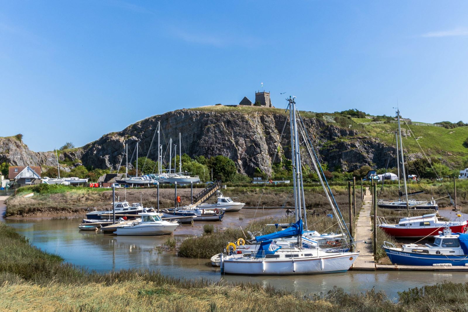 Boats at Uphill Marina which is backed by a big cliff with a church on top